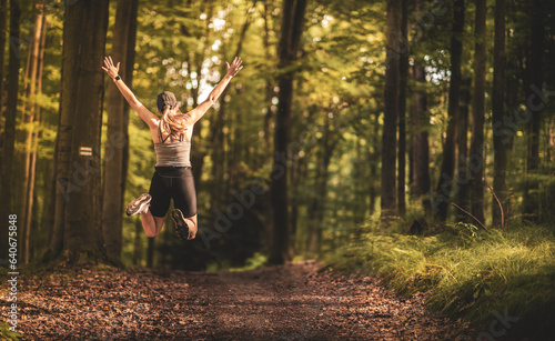 Fitness happiness. Happy woman jumping in the forest. Running in the forest.