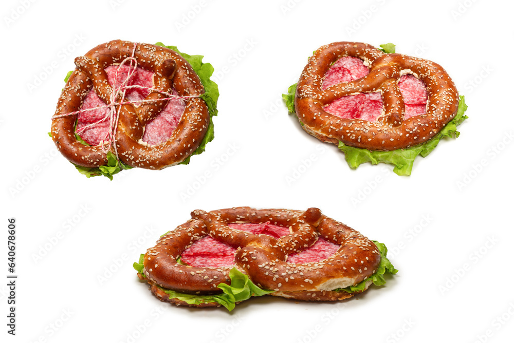 Pretzel with salami and lettuce isolated on a white background. Pretzel with salami and lettuce isolated on a white background.
