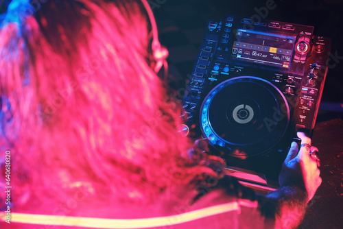 Faceless DJ in headphones playing song in club photo