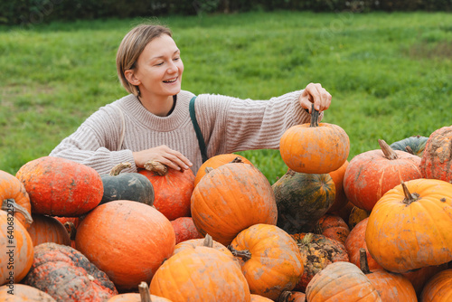 Young woman choosing pumpkins at farm shop. photo