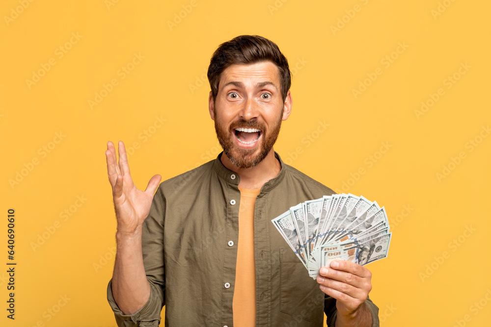 Φωτογραφία Surprised excited middle aged man in casual holding dollar cash money and lookin