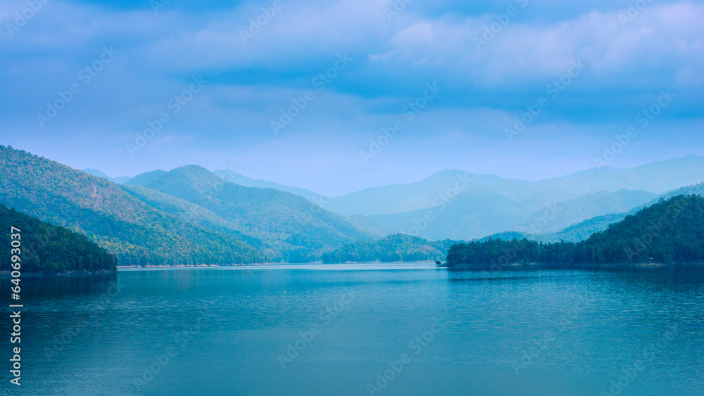 Beautiful intricate landscape, mountain lake view on sky cloudy background.