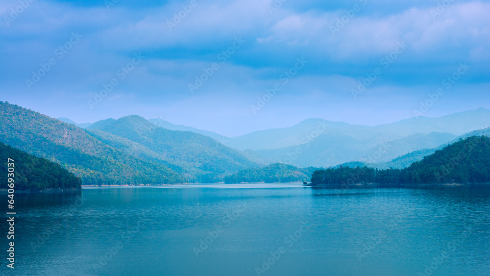Naklejka premium Beautiful intricate landscape, mountain lake view on sky cloudy background.