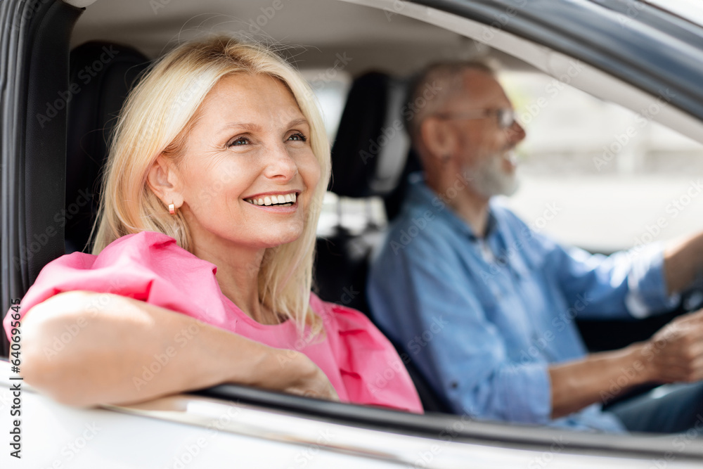 Cheerful senior couple travellers enjoying car trip together Cheerful senior couple travellers enjoying car trip together