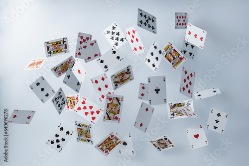 Falling playing cards on a white background. The concept of excitement. Poker cards of different suits hanging in the air