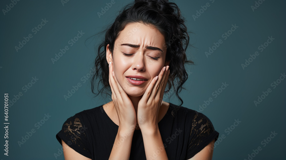 Woman with toothache touch her cheek with hands on blue background Woman with toothache touch her cheek with hands on blue background