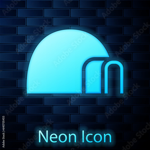 Glowing neon Igloo ice house icon isolated on brick wall background. Snow home, Eskimo dome-shaped hut winter shelter, made of blocks. Vector