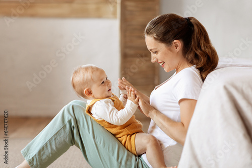 Canvastavla Loving young mother caressing her cute baby boy, home interior