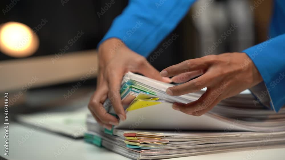 Businessman man working in stacks of papers searching for unfinished paperwork information on form check stack on table and checking financial papers in busy workload