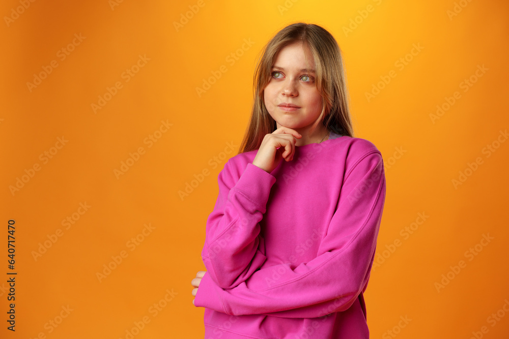 Thinking teen girl in studio over yellow background Thinking teen girl in studio over yellow background