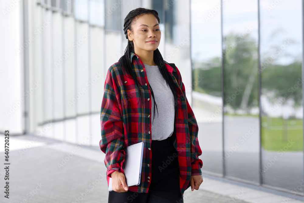Portrait of a modern office worker with a laptop on the background of a building. Portrait of a modern office worker with a laptop on the background of a building.