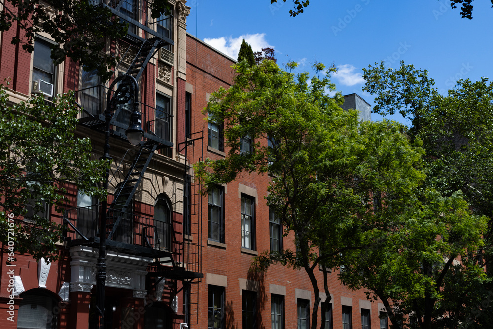 Row of Beautiful Old Brick Apartment Buildings along a Street in the East Village of New York City with Green Trees