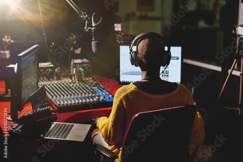 Fotografie Black female broadcaster in dark radio studio