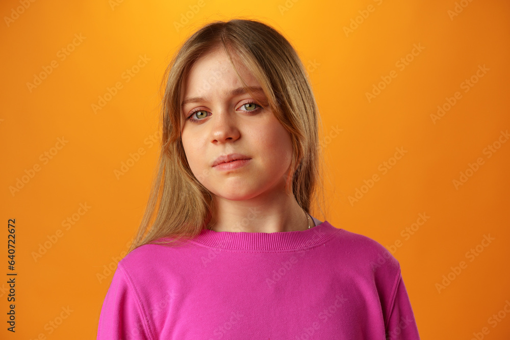 Fototapeta premium Upset disturbed teen girl on yellow background
