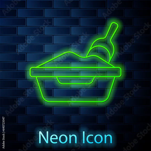 Glowing neon line Cat litter tray with shovel icon isolated on brick wall background. Sandbox cat with shovel. Vector