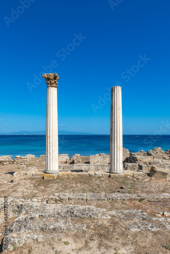 Two Roman columns on the Sinis Peninsula in Sardinia, set against a backdrop of sea and sky.