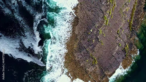 Aerial view of waves crashing on a cliff in Ireland