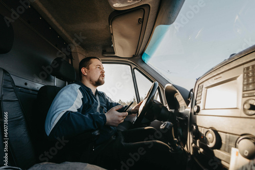 bearded young male truck driver driving a truck. Work as a driver © velimir