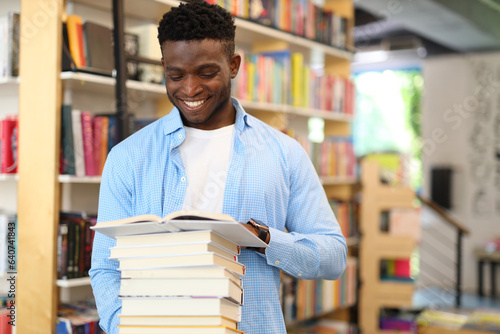 A joyful student in a library, surrounded by books, happily engaging in educational exploration.