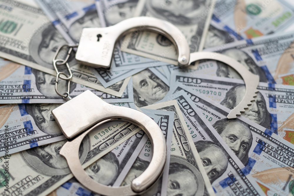 Handcuffs on money background, business security concept Handcuffs on money background, business security concept