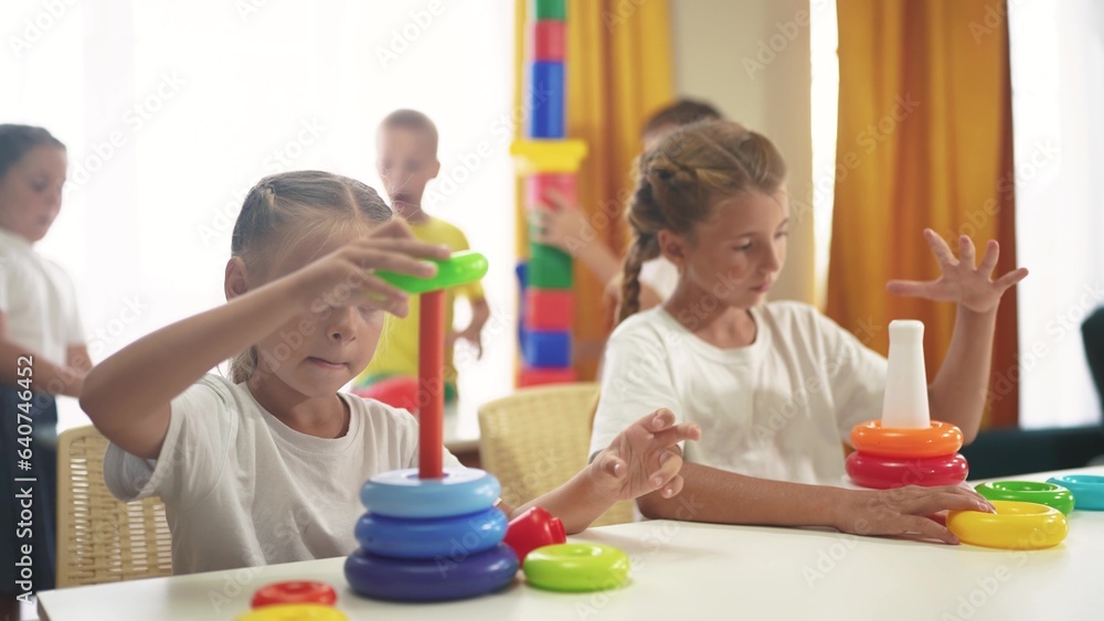 small children play with toys at home. happy family childhood dream concept. lifestyle a group of little kids develops playing with colorful cubes and pyramids. educational games with colored toys small children play with toys at home. happy family childhood dream concept. lifestyle a group of little kids develops playing with colorful cubes and pyramids. educational games with colored toys