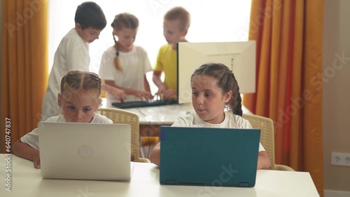 children learn from home through computers. business concept of modern training and development. a group of small kids perform tasks in a laptop at home schooling. lifestyle educating at home