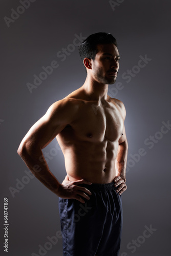 Muscle, body and studio man with fitness challenge results, bodybuilder progress and strong transformation training. Dark shadow, exercise and confident sports athlete thinking on grey background