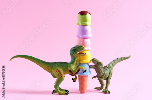 Happy green dinosaurs with huge waffle cone with ice cream on pink background. © dvulikaia