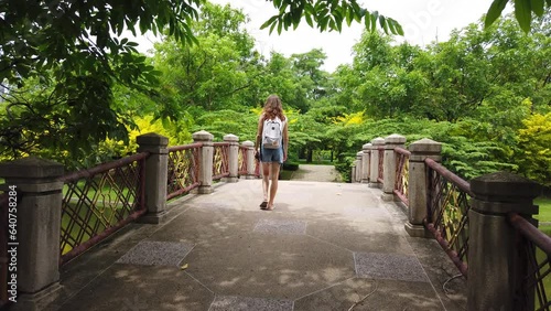 Wallpaper Mural A girl walks through a park in Bangkok. Woman hiking alone. Summer park. Torontodigital.ca