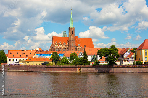 The waterside of Oder river and background оф Collegiate Church of the Holy Cross and St. Bartholomew in Wroclaw, Poland. It is a Gothic church in Ostrow Tumski