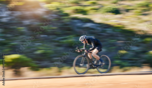 Motion blur, fitness and cyclist on bicycle on road in mountain with helmet, exercise adventure trail and speed. Cycling race, nature and man with bike for fast workout, training motivation or energy
