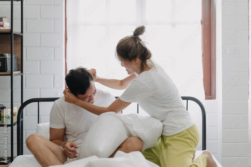 Asian wife and husband playing pillow fight funny and laugh on the bed. Asian wife and husband playing pillow fight funny and laugh on the bed.