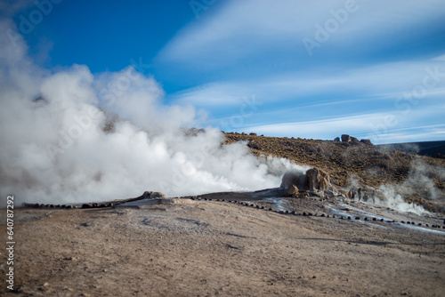 the wind is pushing the steam of some gaisers of El Tatio, Antofagasta, Atacama, Chile photo