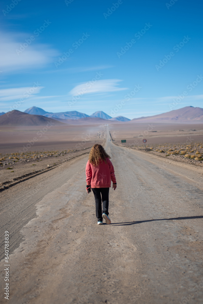 close up of a woman walking in the middle of the road to El Tatio