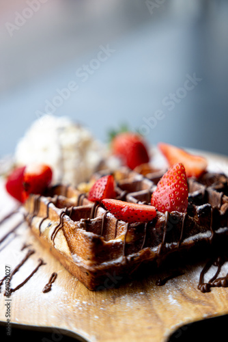 waffle with chocolate sauce on a platter with whipped cream