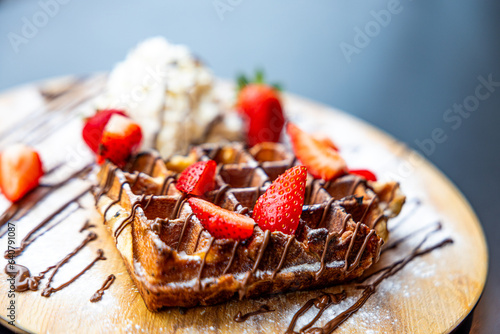 waffle with chocolate sauce on a platter with whipped cream