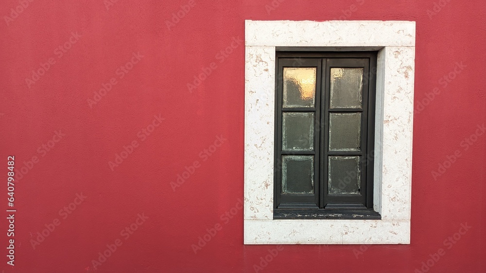 Naklejka premium Wooden old window in an old castle with red walls and a stone window frame