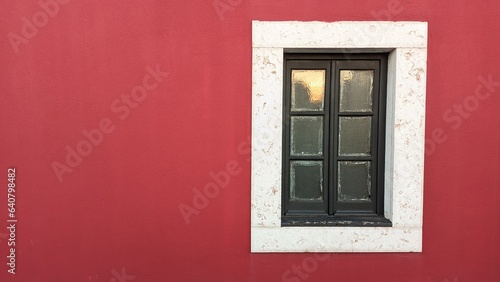 Wooden old window in an old castle with red walls and a stone window frame