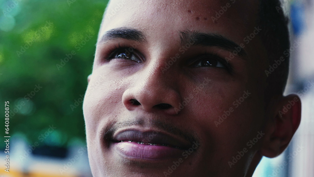 Obraz premium Religious Brazilian young man close-up face closing eyes and gazing upwards in Spiritual contemplation