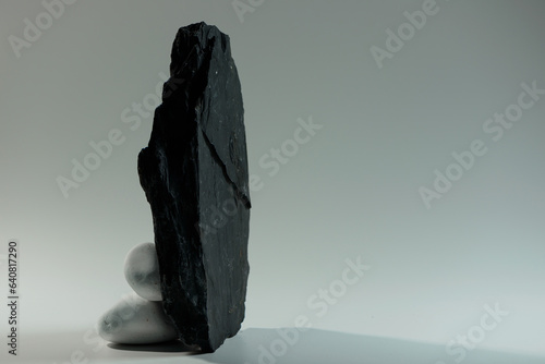 small white smooth stones behind one big black flat stone 
