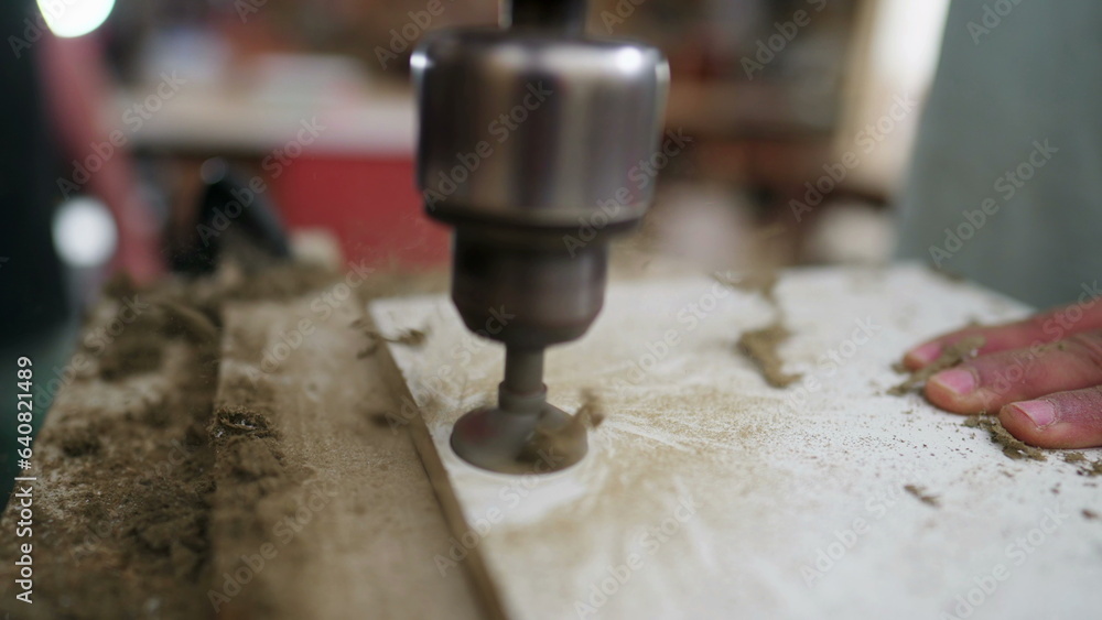 Drilling machine making a hole into a wooden surface at high-speed motion. Carpentry equipment detail close-up Drilling machine making a hole into a wooden surface at high-speed motion. Carpentry equipment detail close-up