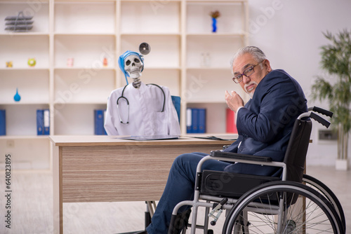 Old patient in wheel-chair visiting devil doctor
