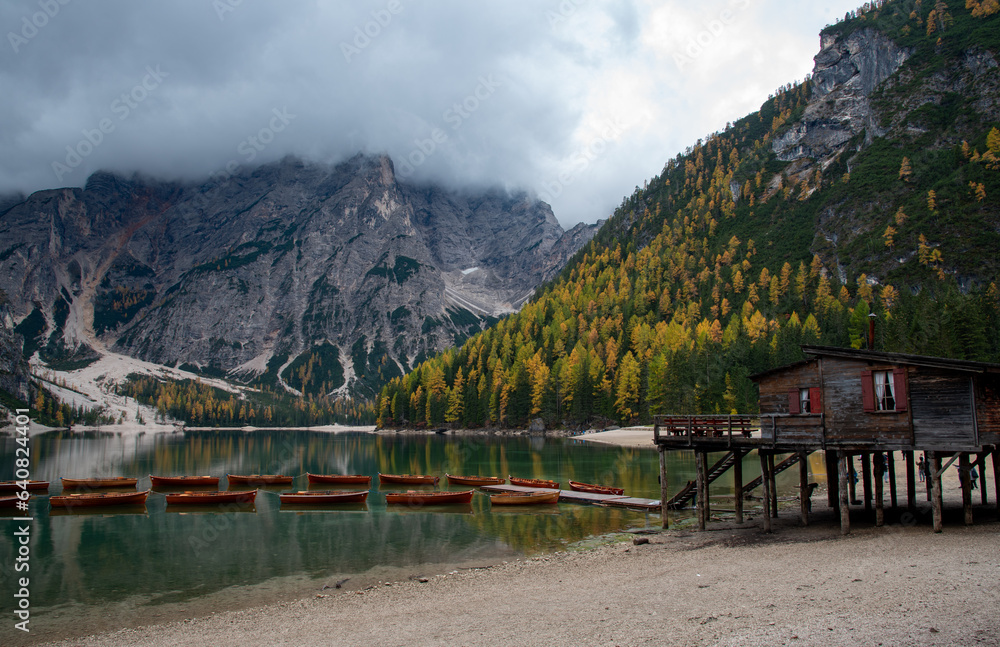 Wooden boats and Lago di Braies in Dolomites, and seekofel dolomite massif in Italy Europe Wooden boats and Lago di Braies in Dolomites, and seekofel dolomite massif in Italy Europe