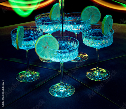 A glass of wine reflected in mirrors and illuminated by colored light