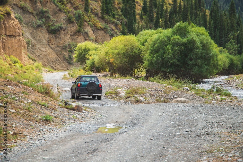 Travel concept with little green 4x4 off-road car driving in summer mountains mud road. Travel concept with little green 4x4 off-road car driving in summer mountains mud road.