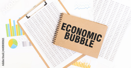Text ECONOMIC BUBBLE on brown paper notepad on the table with diagram. Business concept