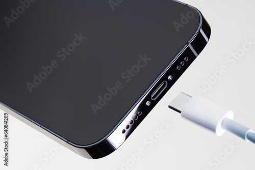 Bottom part of modern smartphone with high speed usb type-c communication port and charging cable. Universal USB type-c charge standard for smartphone. up-to-date technologies for communication.
