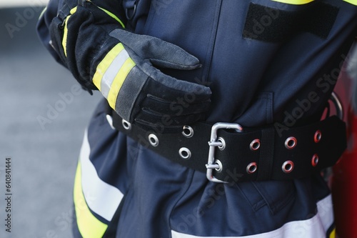 Fireman (firefighter) in action standing near a firetruck. Emergency safety. Protection, rescue from danger.