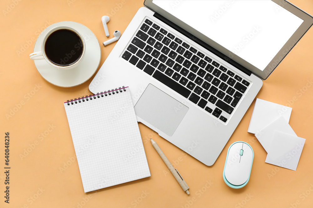 Laptop with earphones, cup of coffee and stationery on orange background Laptop with earphones, cup of coffee and stationery on orange background