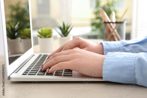 Woman working with modern laptop on comfortable workplace